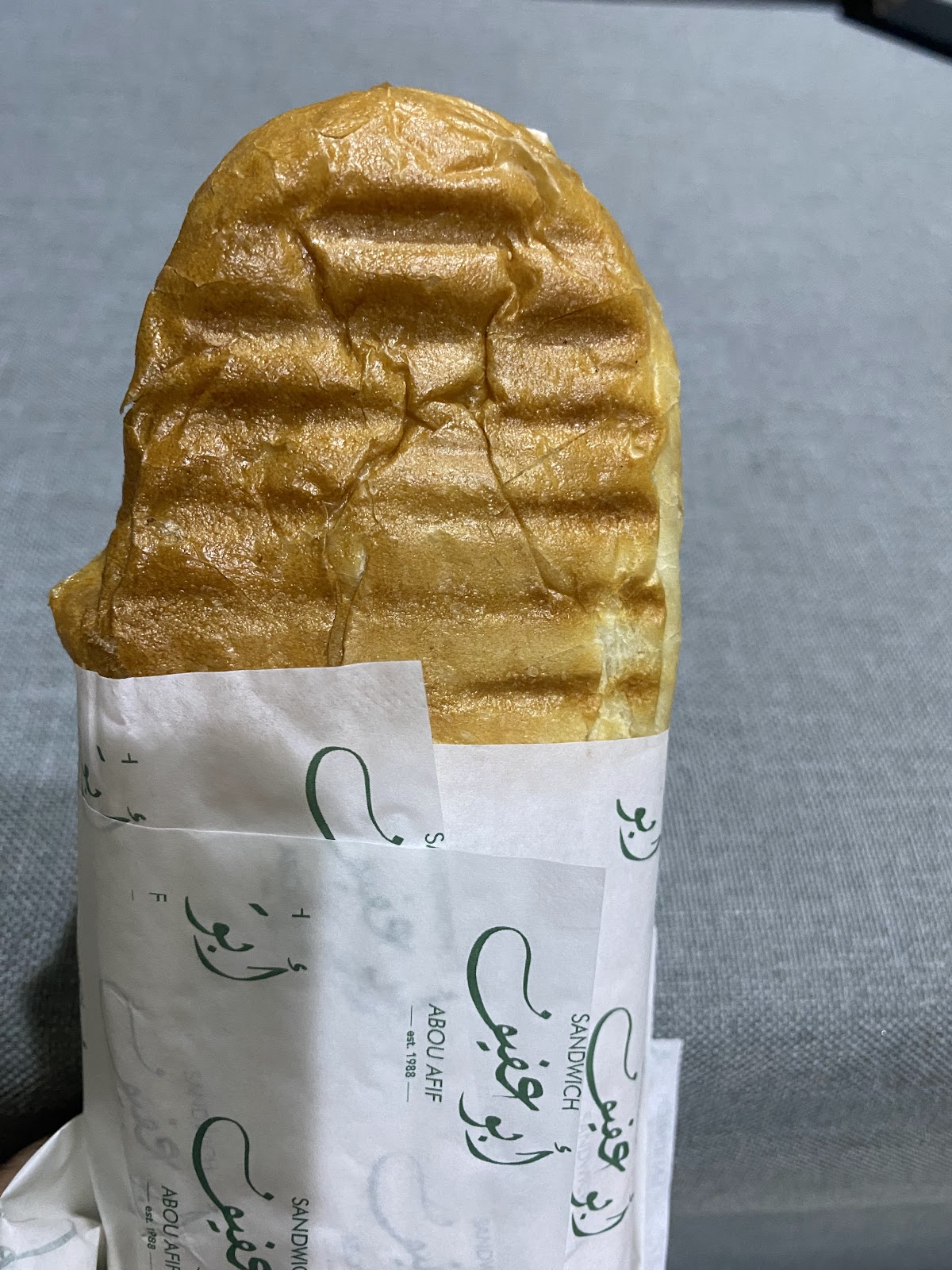 An Abou Afif sandwich pressed golden and wrapped in the shop's own paper