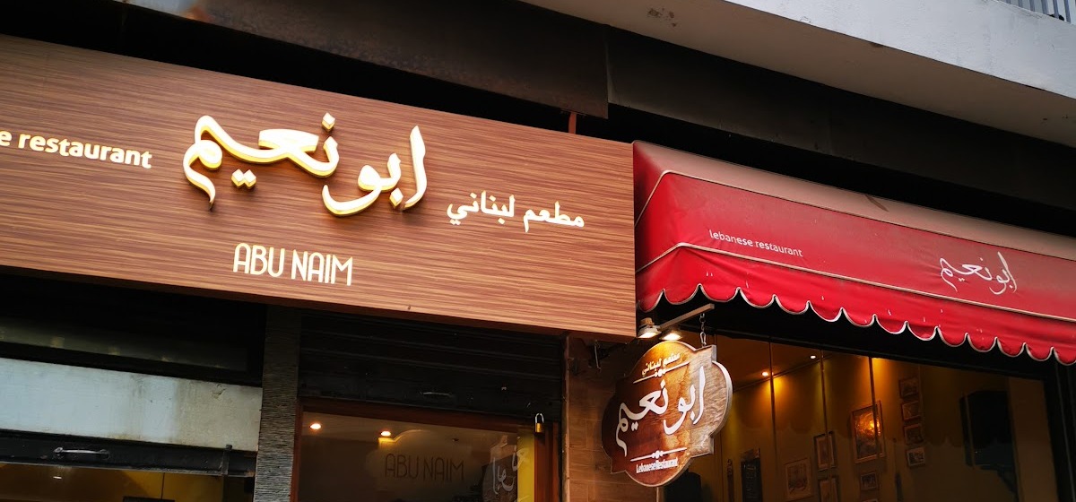 The Abu Naim frontage on Abdel Aziz Street, the wood fascia and red awning with the name in Arabic and Latin