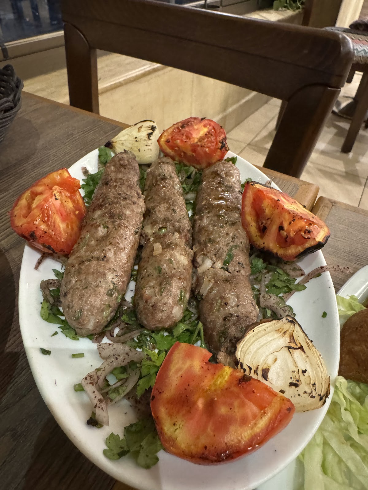 Kebab skewers with grilled tomato and onion on a platter