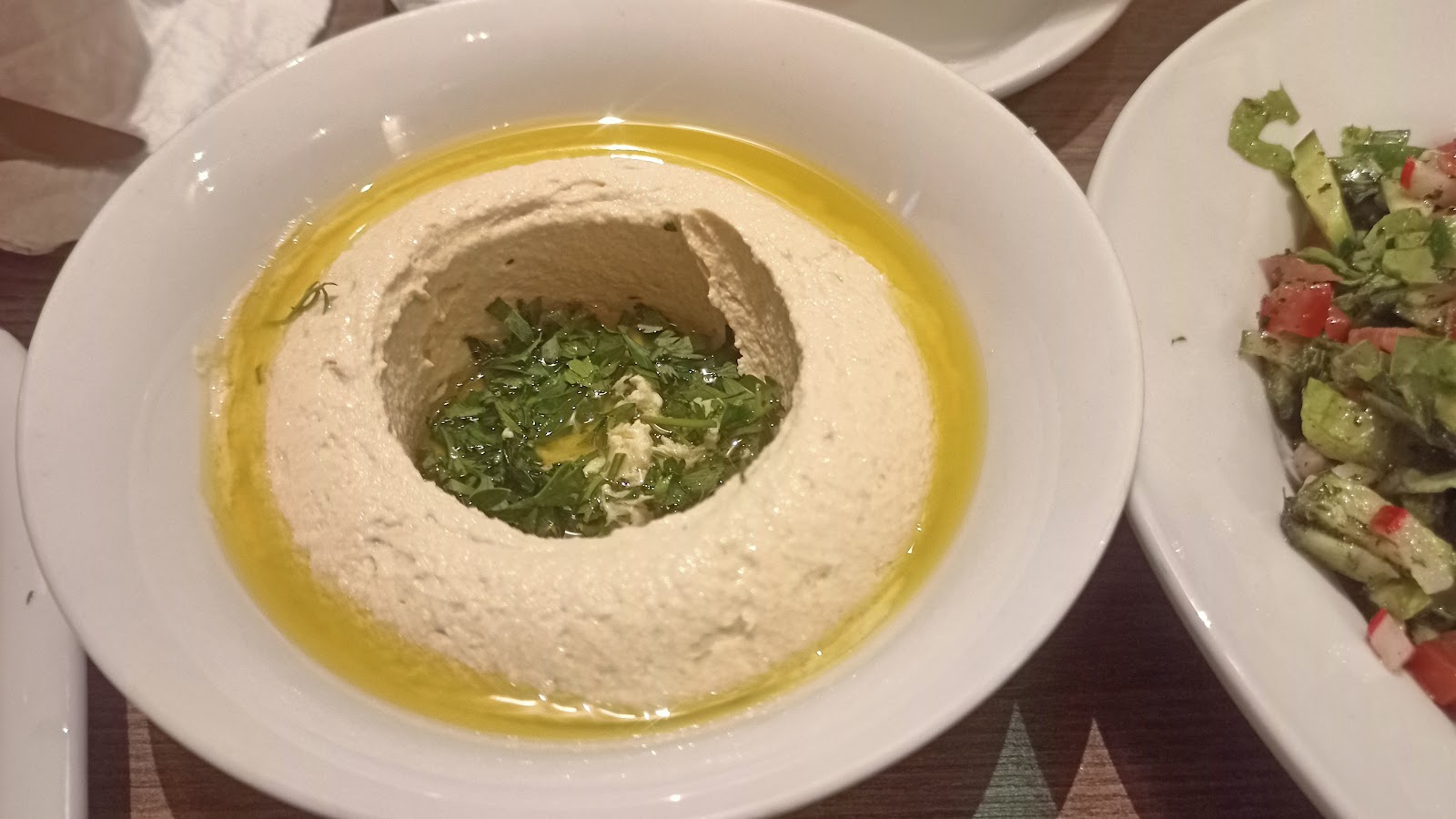 A bowl of labneh with olive oil and herbs