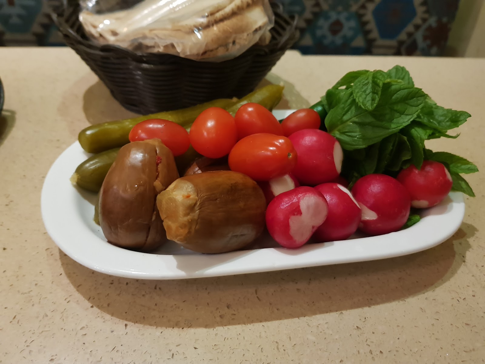Radishes, pickles and bread land first on the table