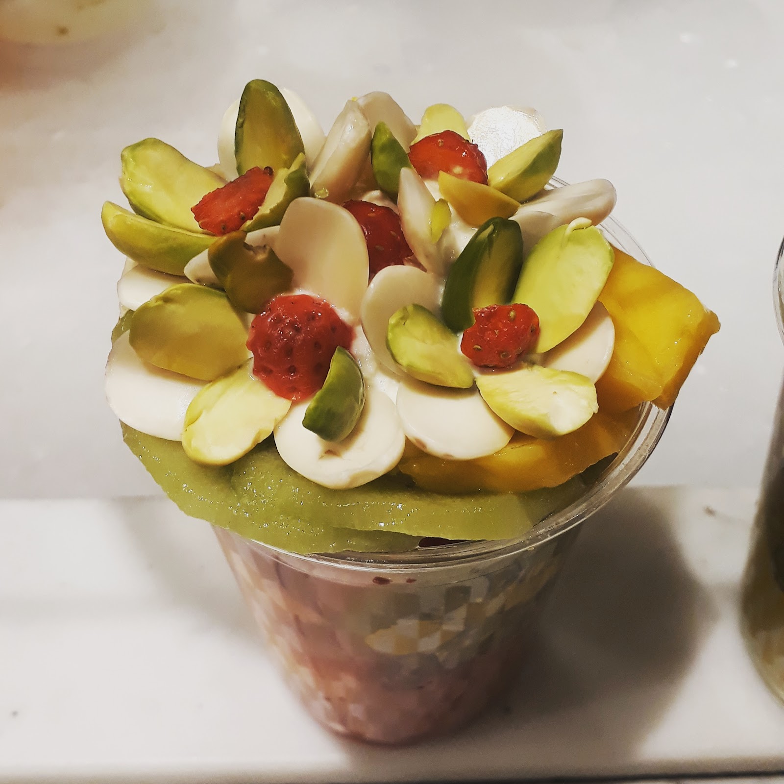 An Al Antabli fruit cocktail topped with ashta, pistachio and almond