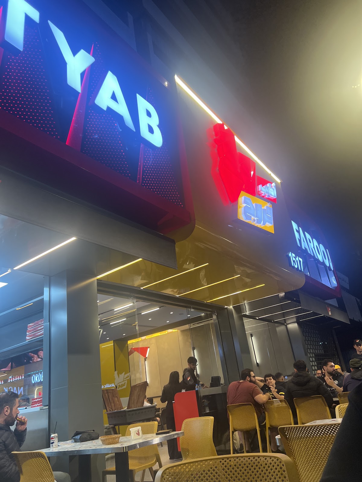 The Atyab Farooj neon sign glowing over the corniche corner at night