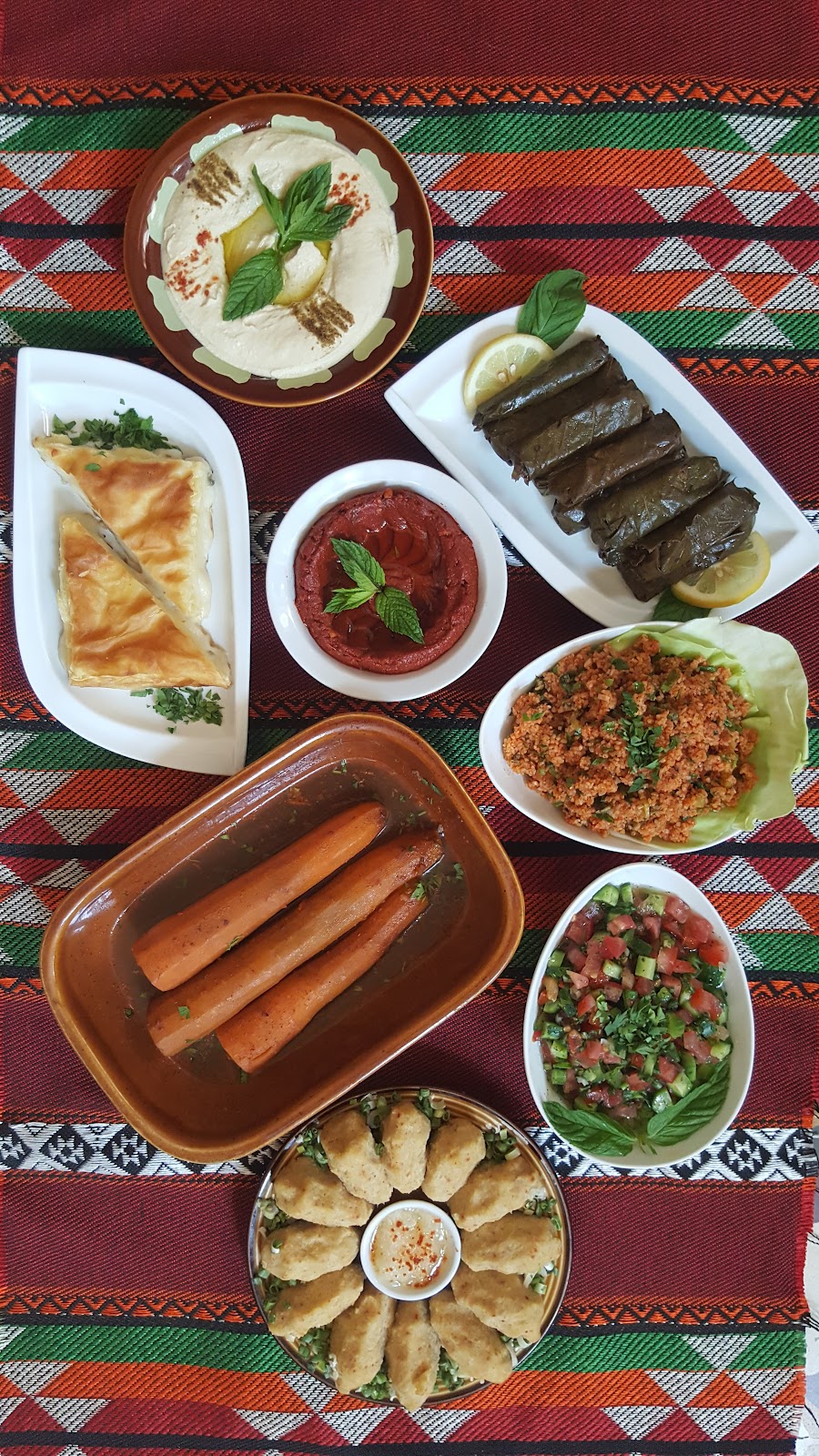 An Armenian spread of soujouk, sarma, cheese boereg and mezze on a patterned cloth