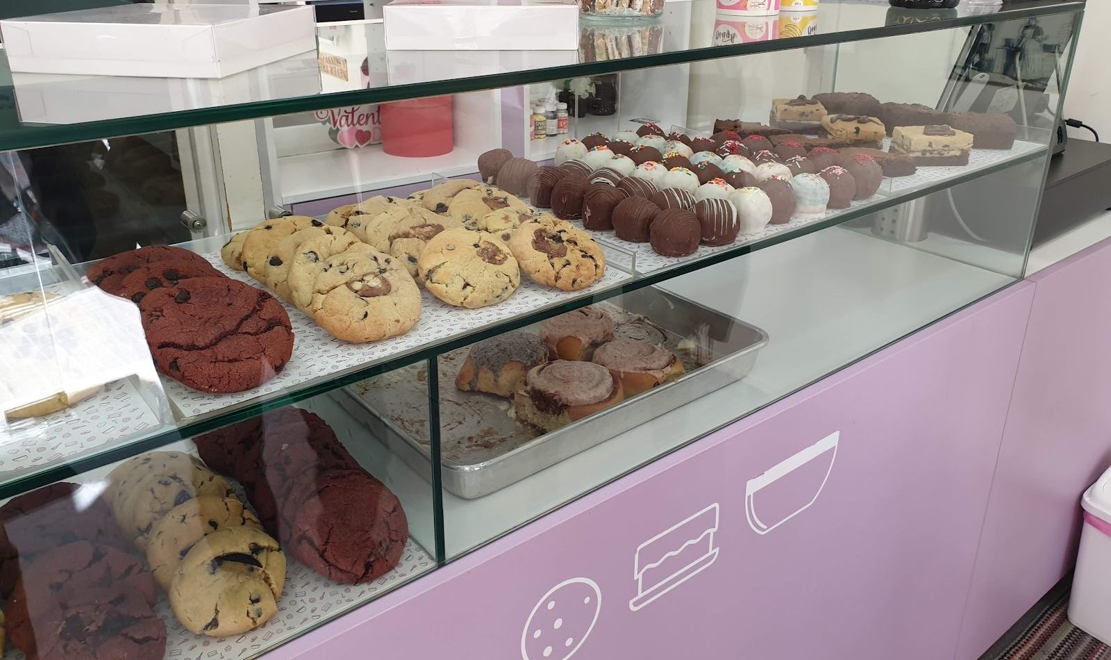 The pink counter at Better From Scratch, cookies and cake truffles behind glass