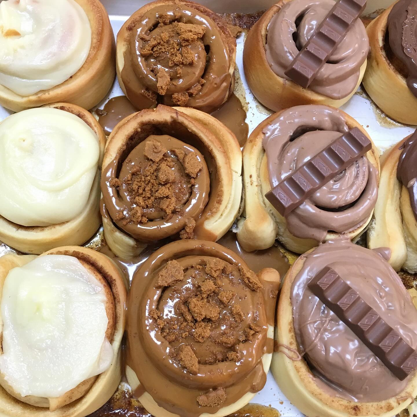 Cinnamon rolls glazed with cream, caramel and chocolate