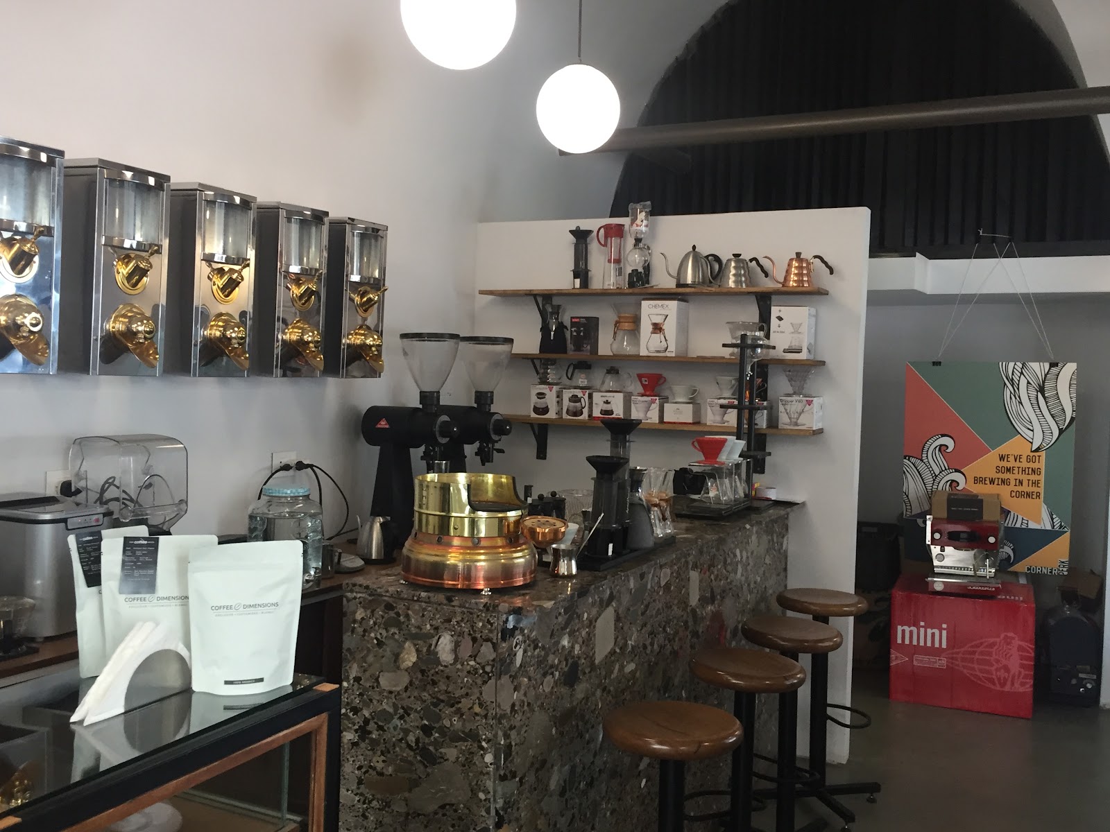 The Bn bar itself: bean silos, two grinders and the brew shelf behind the stone counter