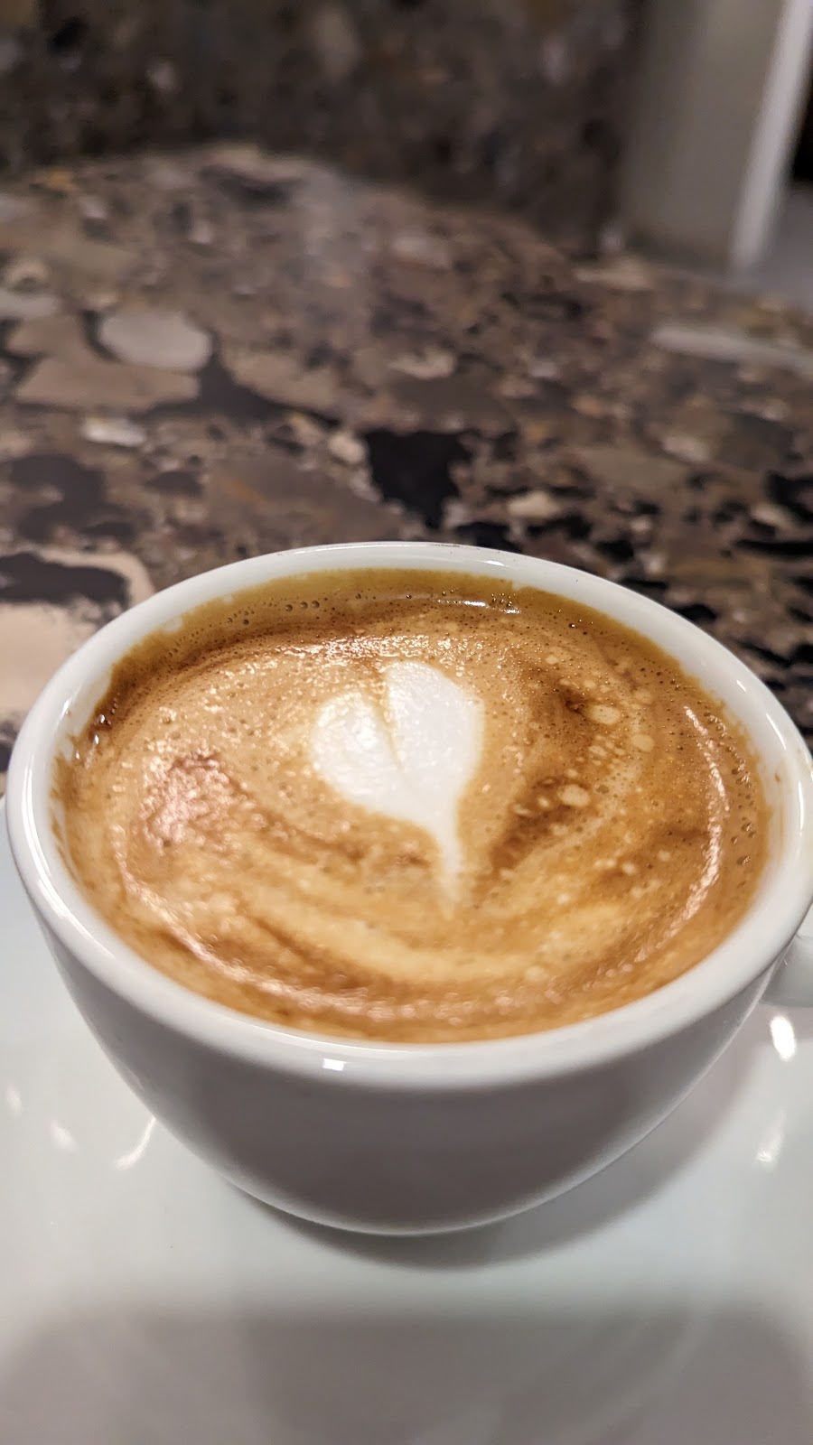 A cortado with a heart poured in the foam