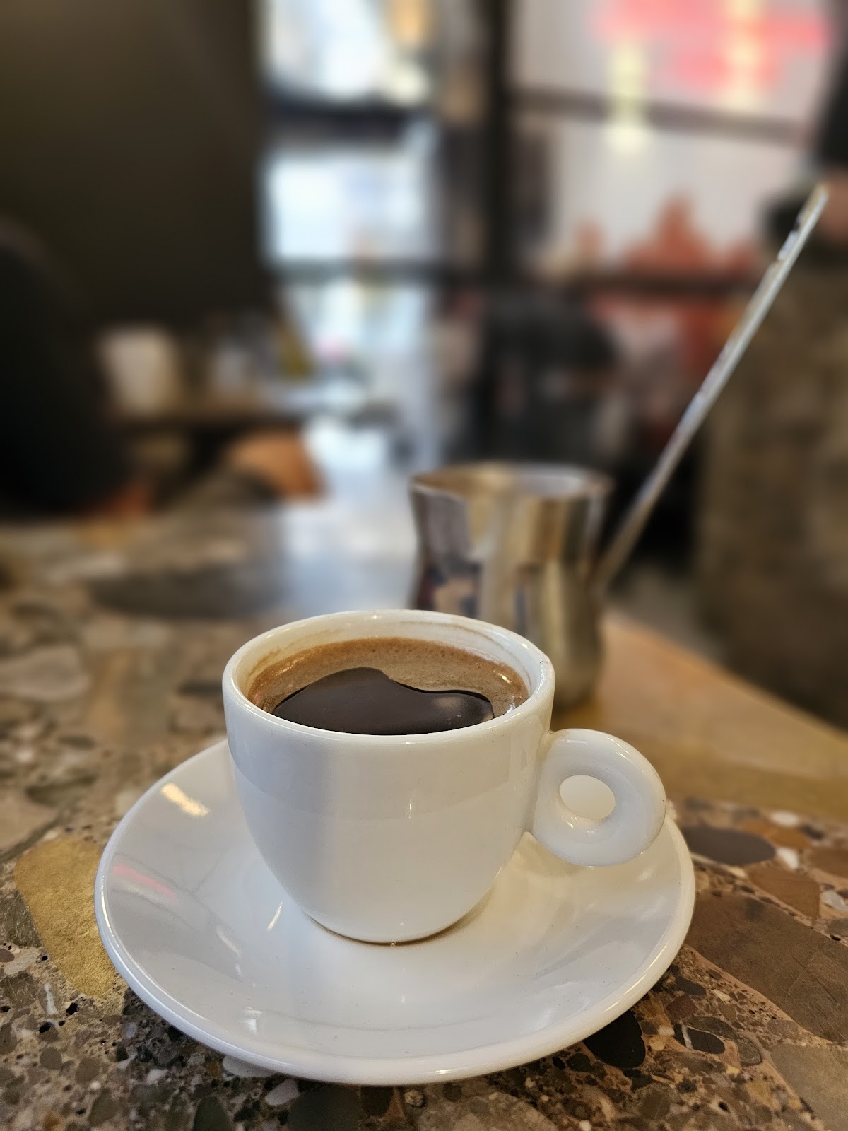 A black coffee on the terrazzo counter by the window