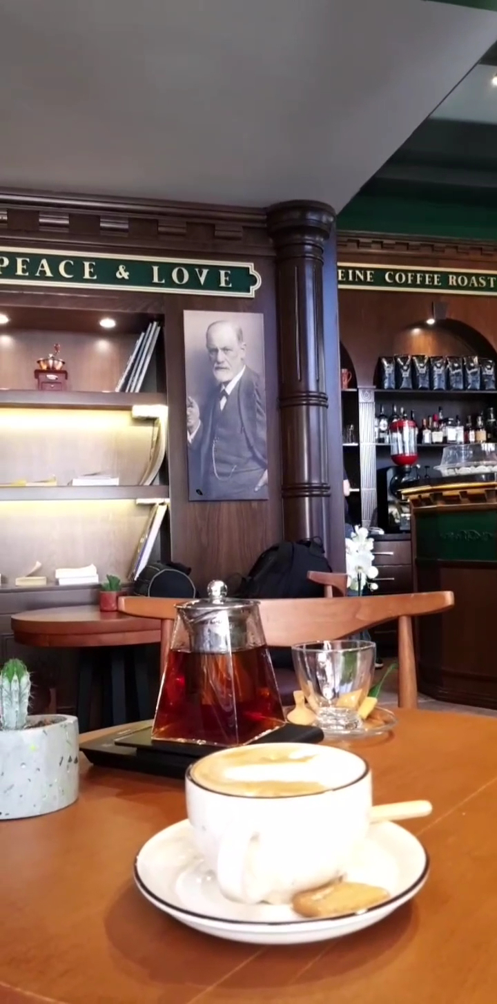 A glass teapot and a white cup on the counter