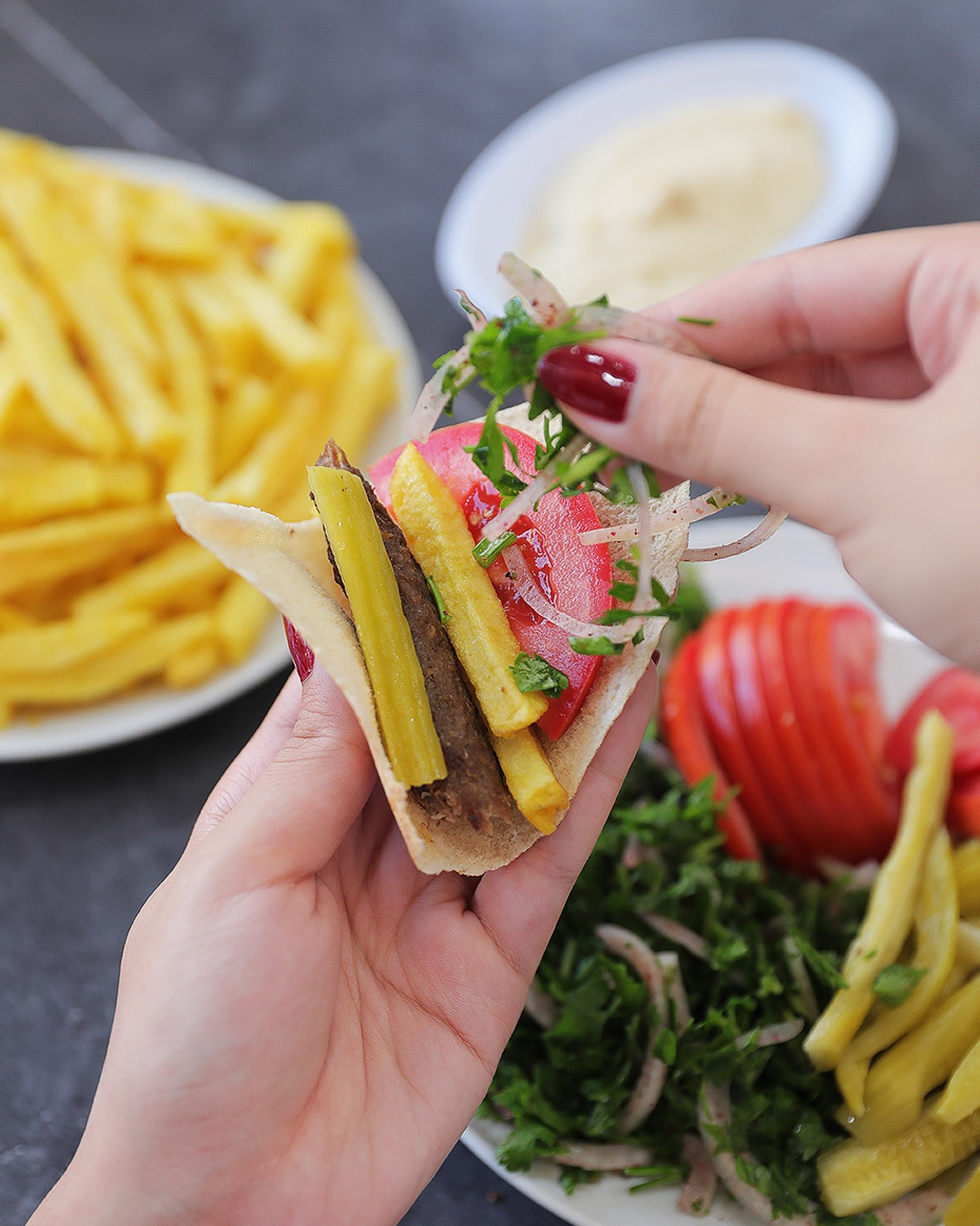A sandwich held open with chips and pickles tucked inside