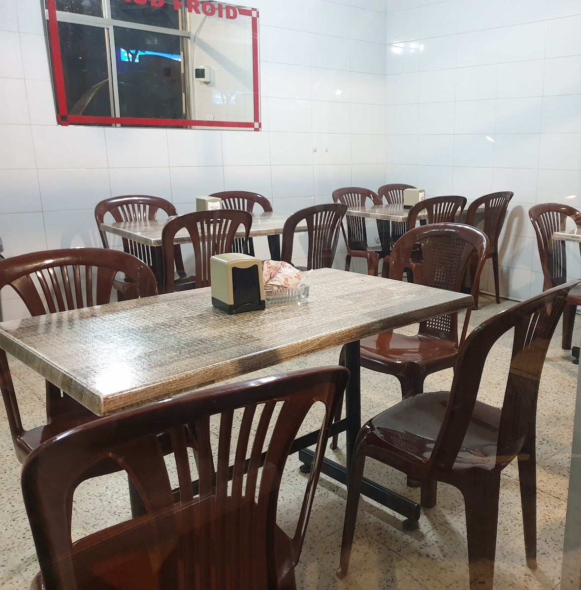 The tiled dining room at Chaud Froid with its marble tables and wooden chairs