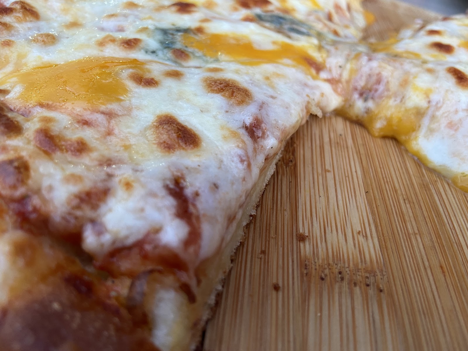 A close-up of the deep dish cheese pull on the wooden board