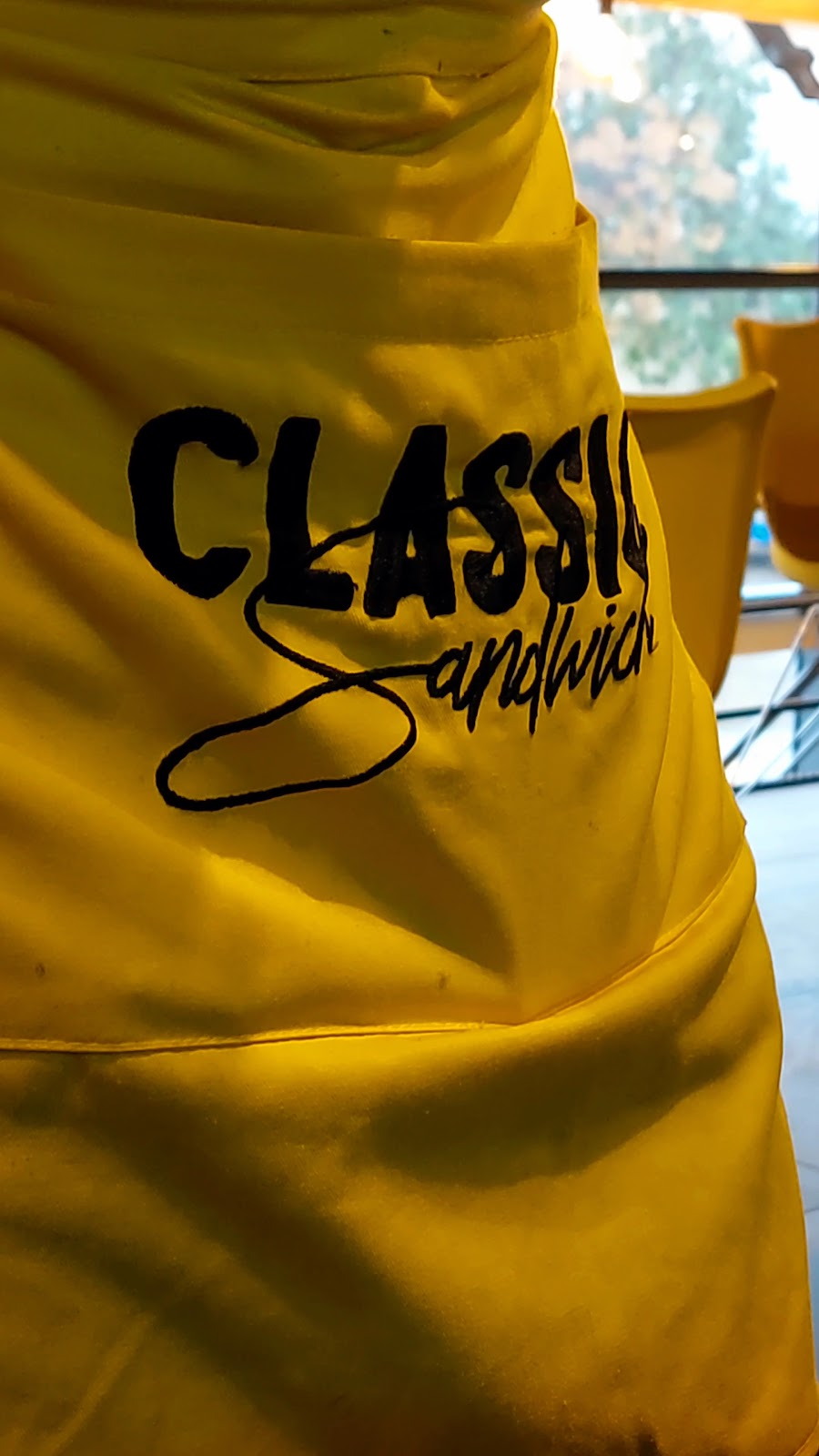 The house apron in yellow with the name stitched across it