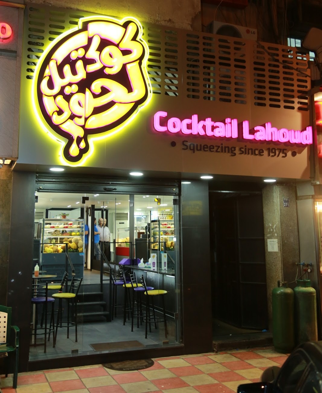 The shop sign lit at night on Armenia Street