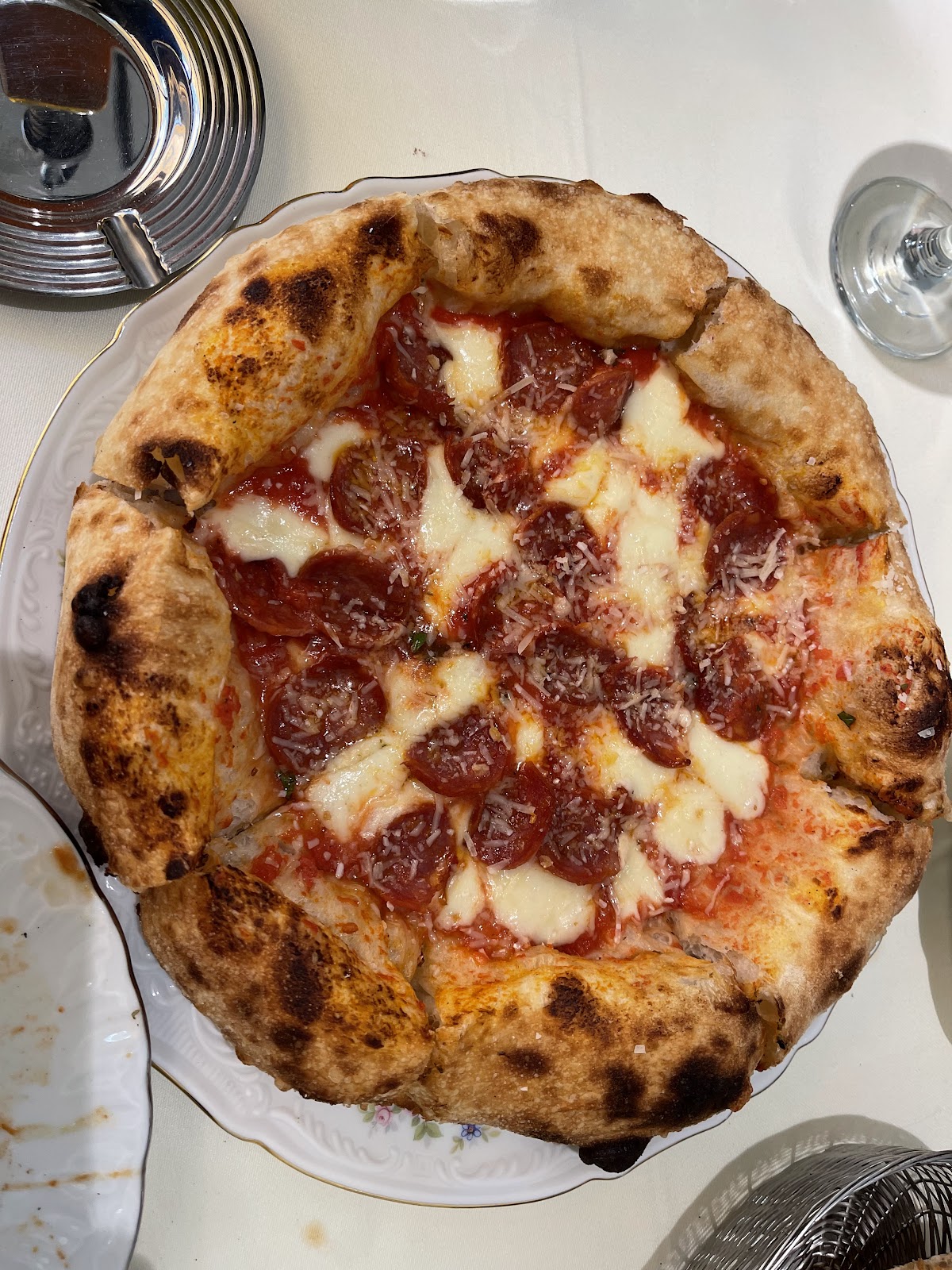 A blistered-crust pizza with cured slices, seen from above