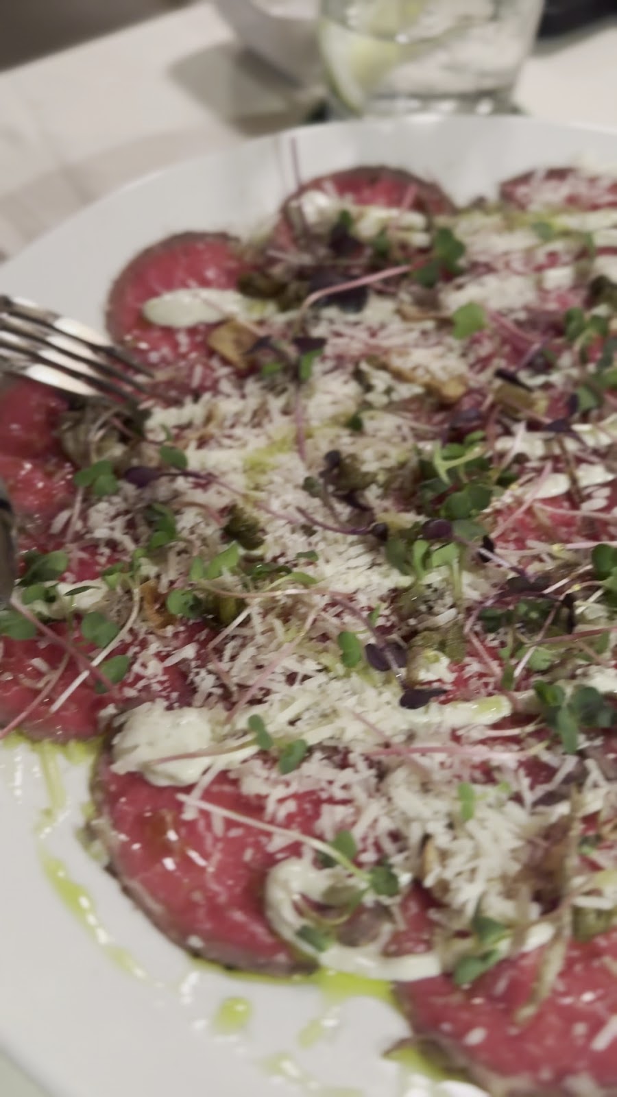 Beef carpaccio with rocket, shaved cheese and olive oil