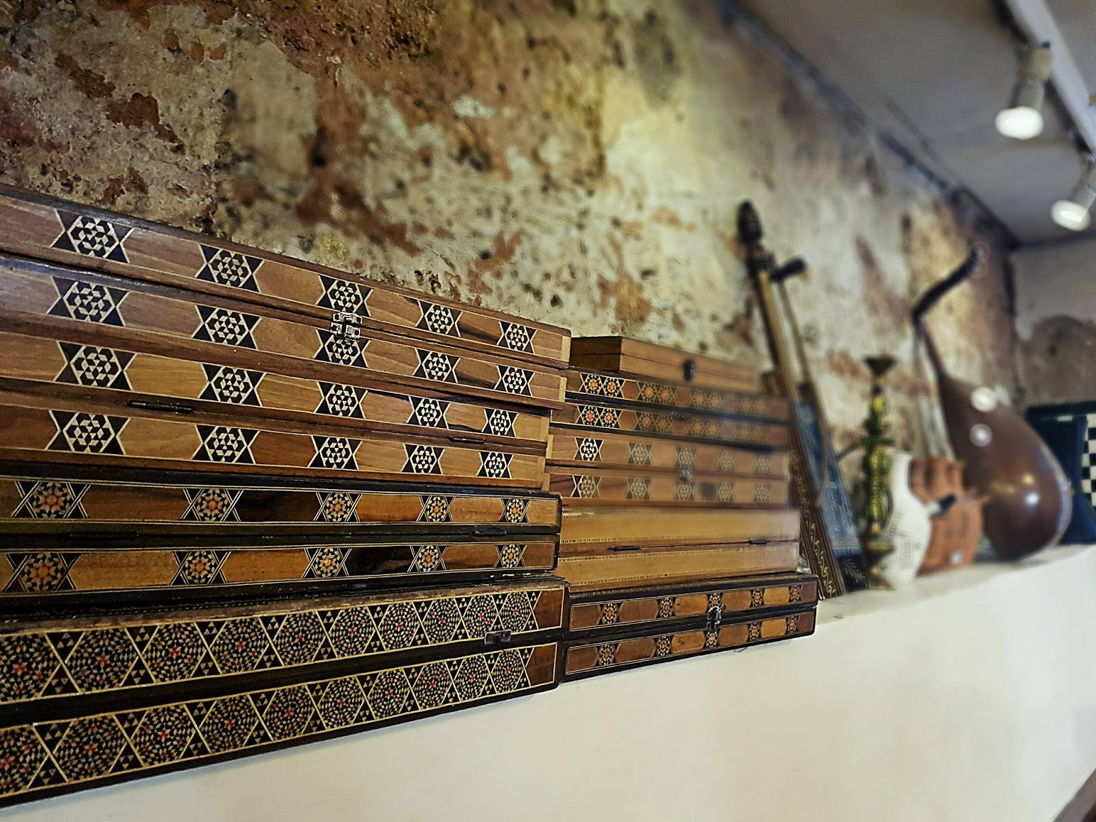 Inlaid qanun instruments displayed along the stone wall