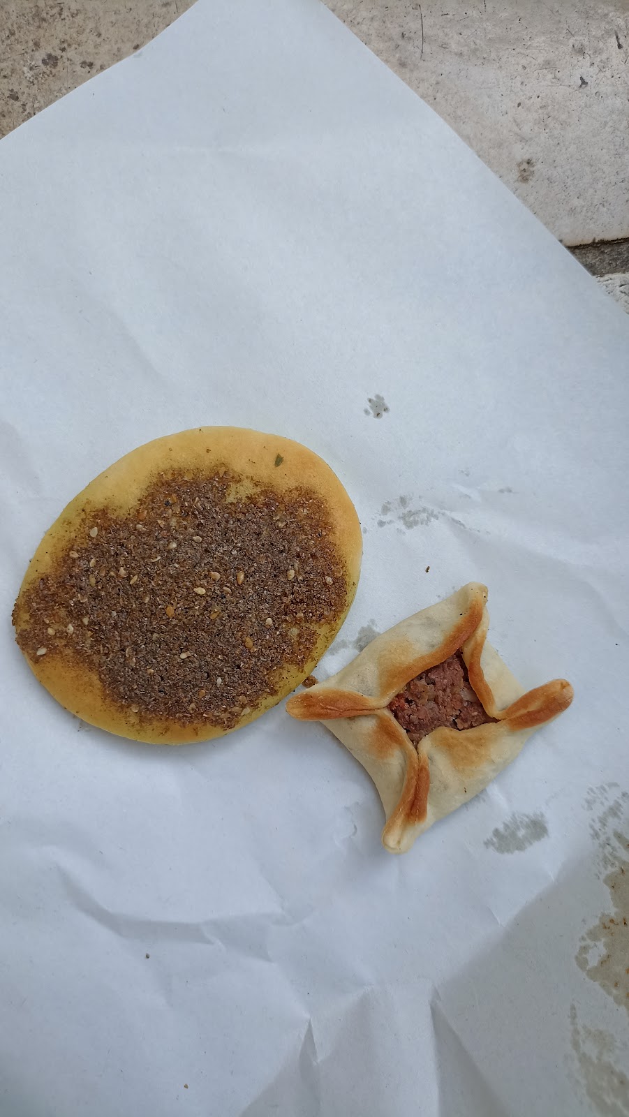 A zaatar manousheh and a meat sfiha on paper