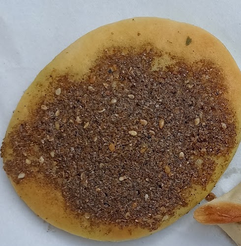 A round zaatar manousheh from Furn Abdel Aziz, oil and zaatar spread to the edge