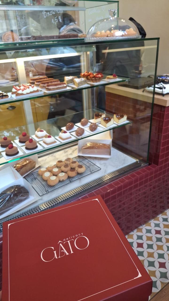 The red tiled display cases with cakes and a Gato box