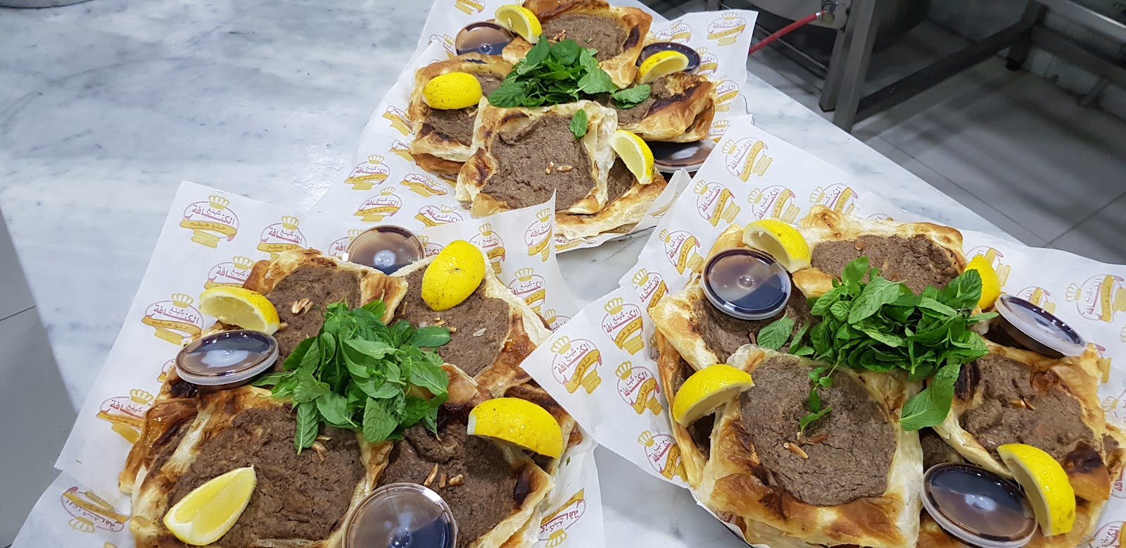 Several ka'akeh knafeh plates lined up on the marble counter