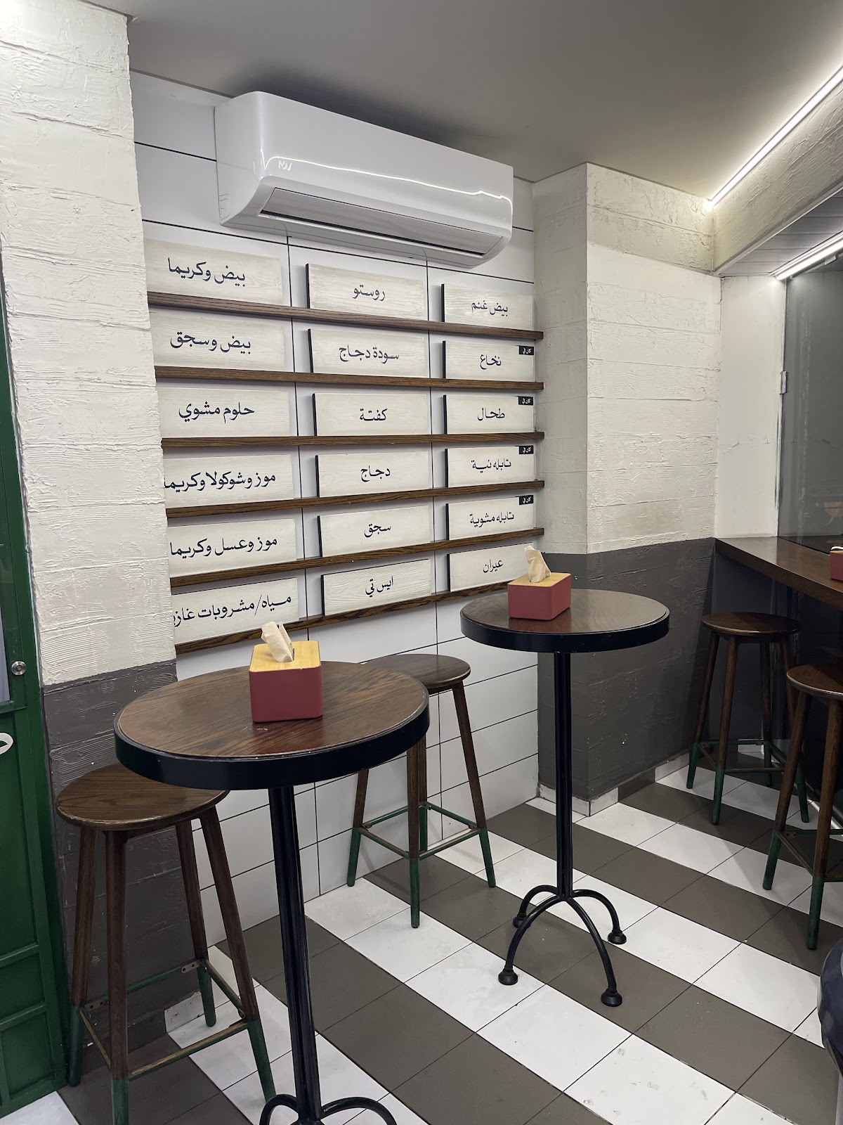 The tiled interior with the wooden menu shelves on the wall