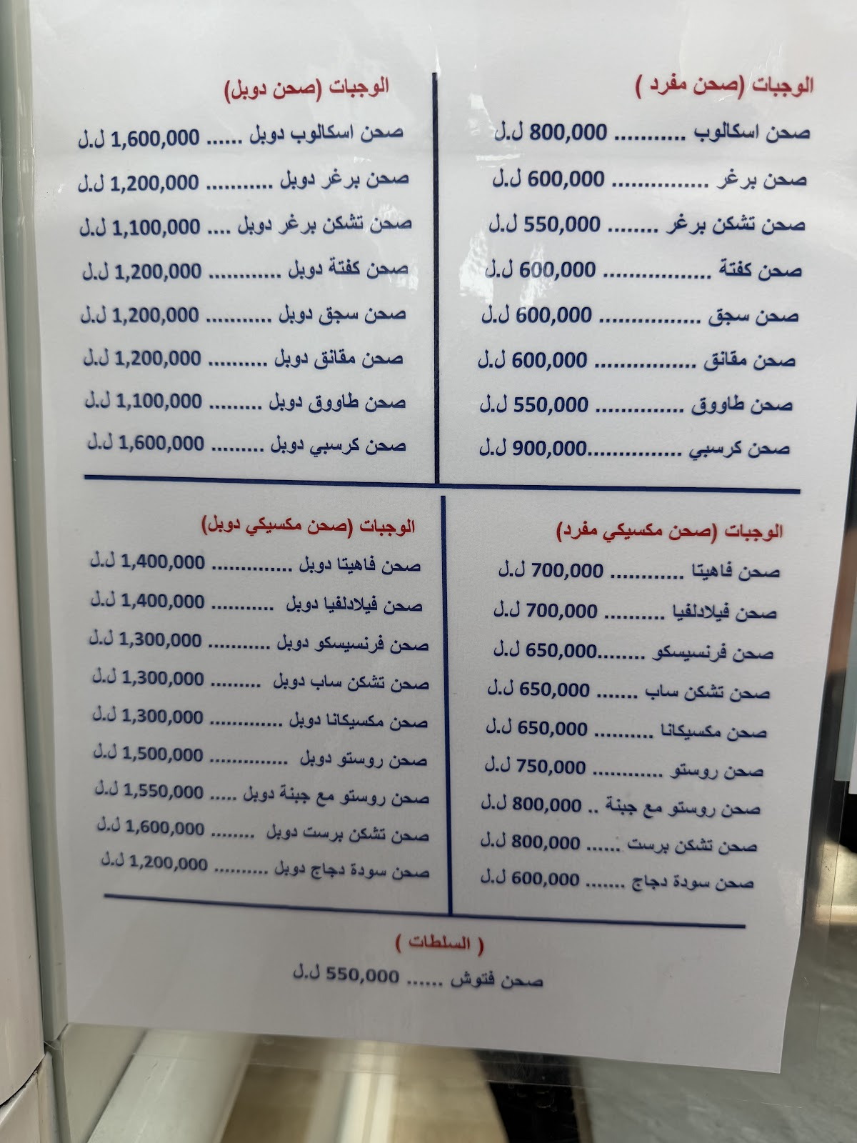 The printed Arabic list of plates and prices photographed at the counter