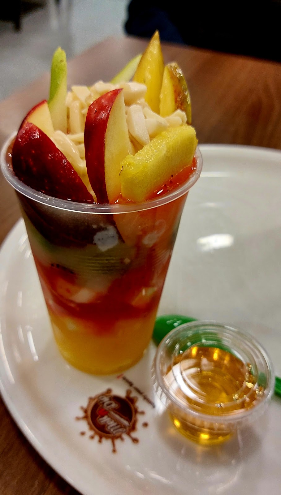 A fruit cocktail cup packed with apple, pineapple and kiwi