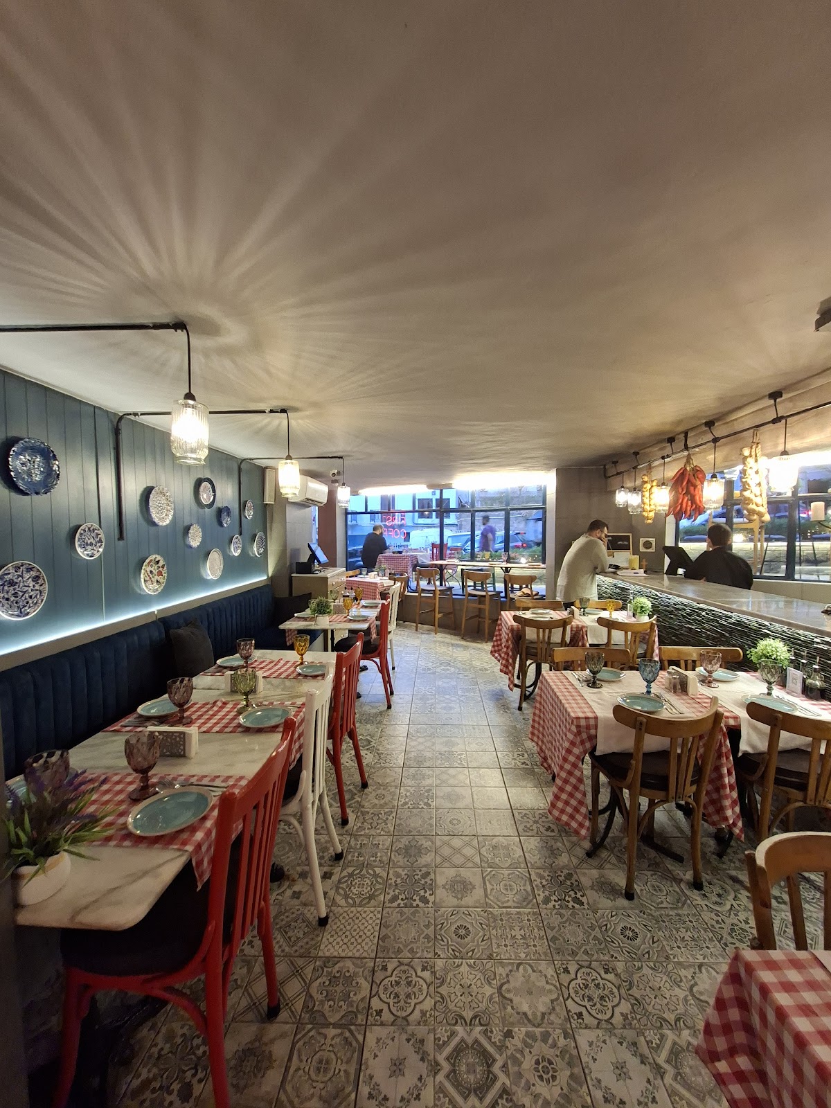 The dining room with red gingham tables and patterned tile floor