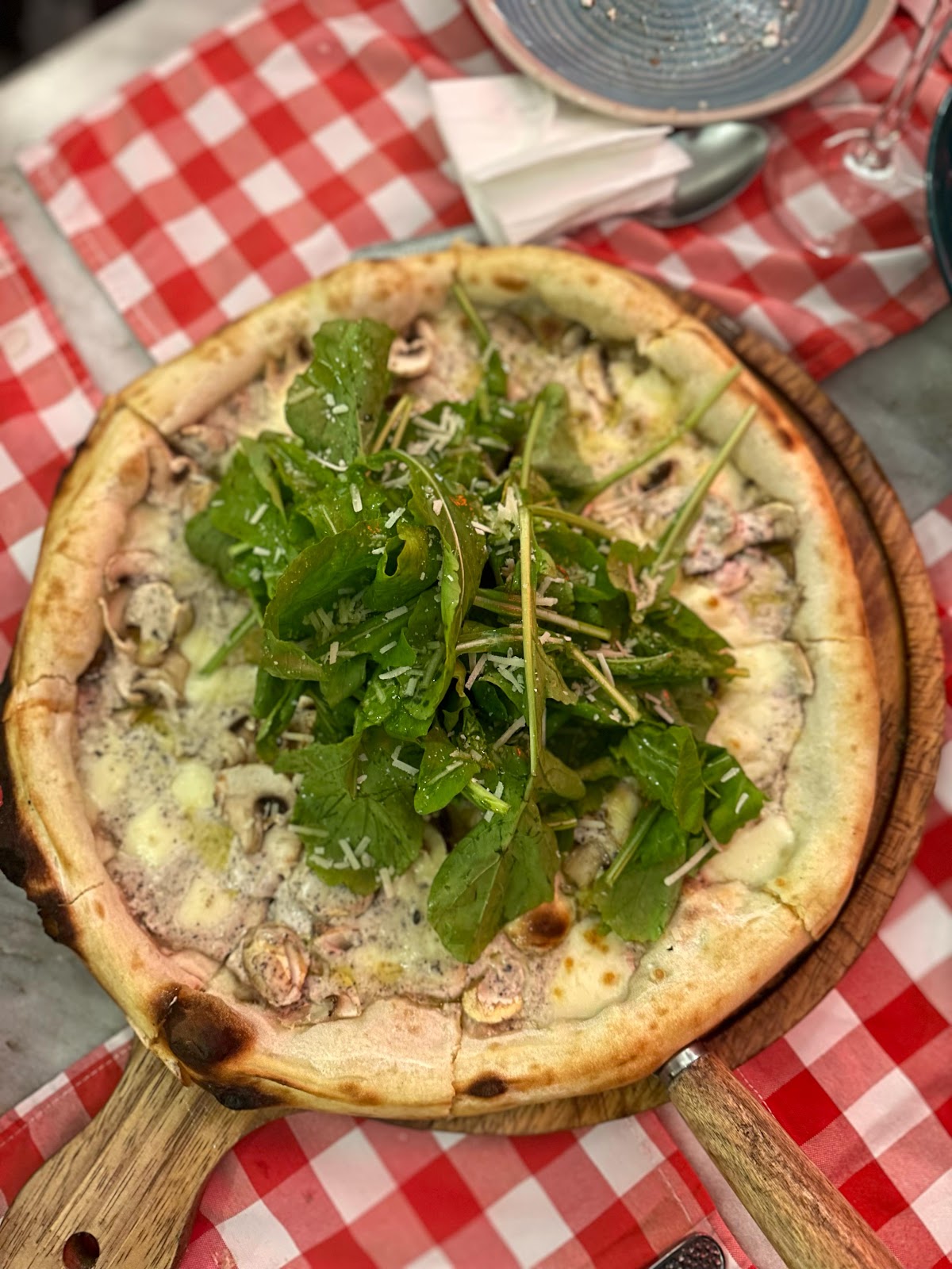 The Tartuffo pizza with mushrooms and rocket on a wooden paddle at Mamma in Cucina