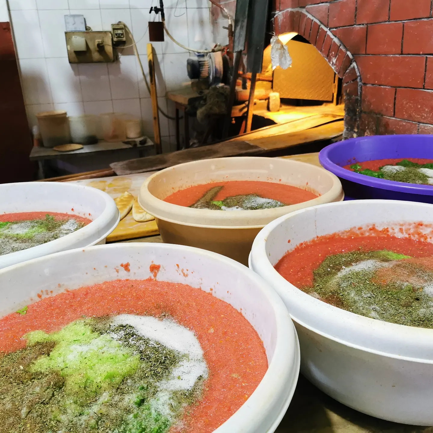 The brick oven at Afran Maraach with basins of tomato and za'atar mix waiting beside it