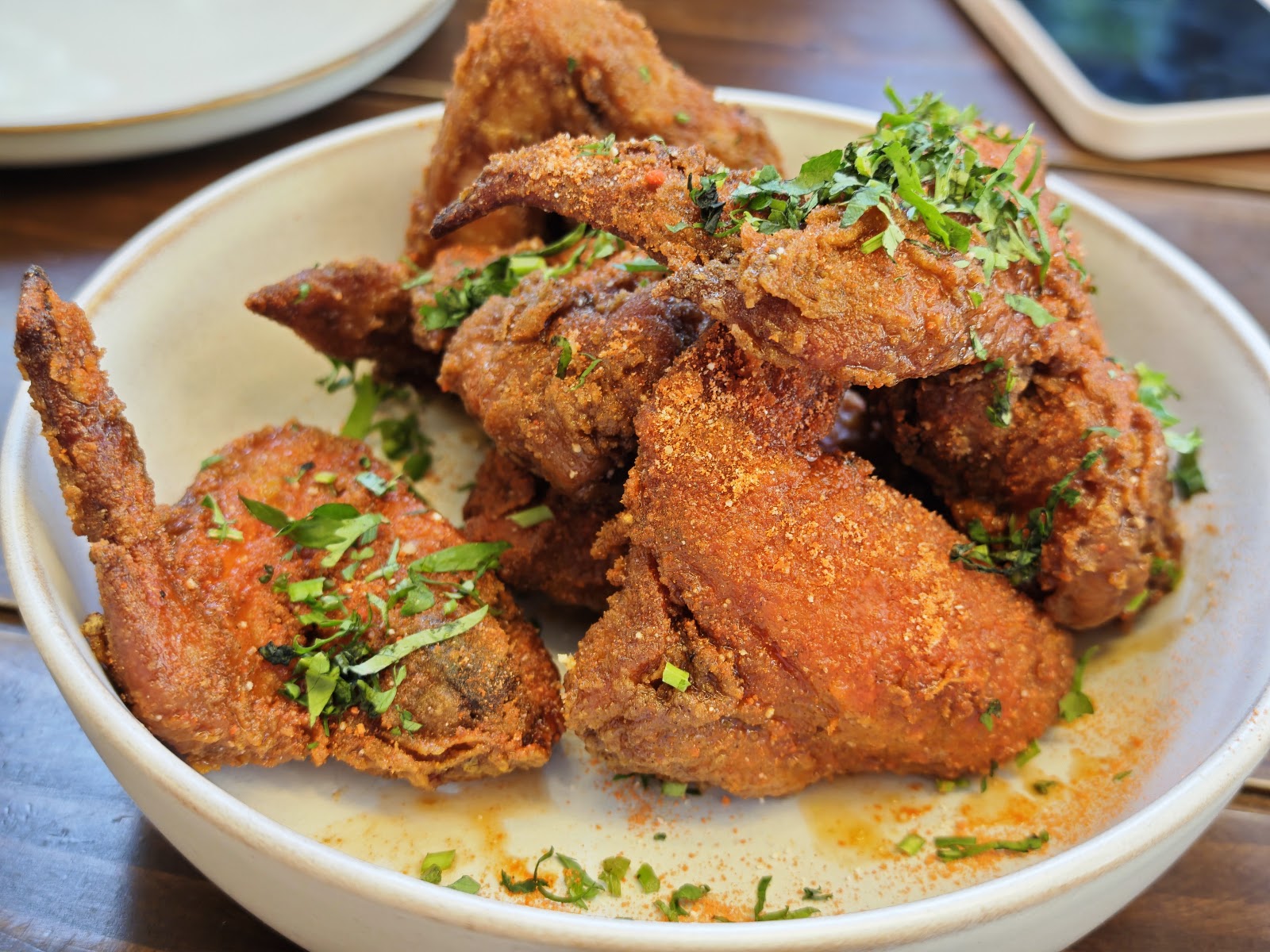 Fried chicken pieces with herbs in a white bowl