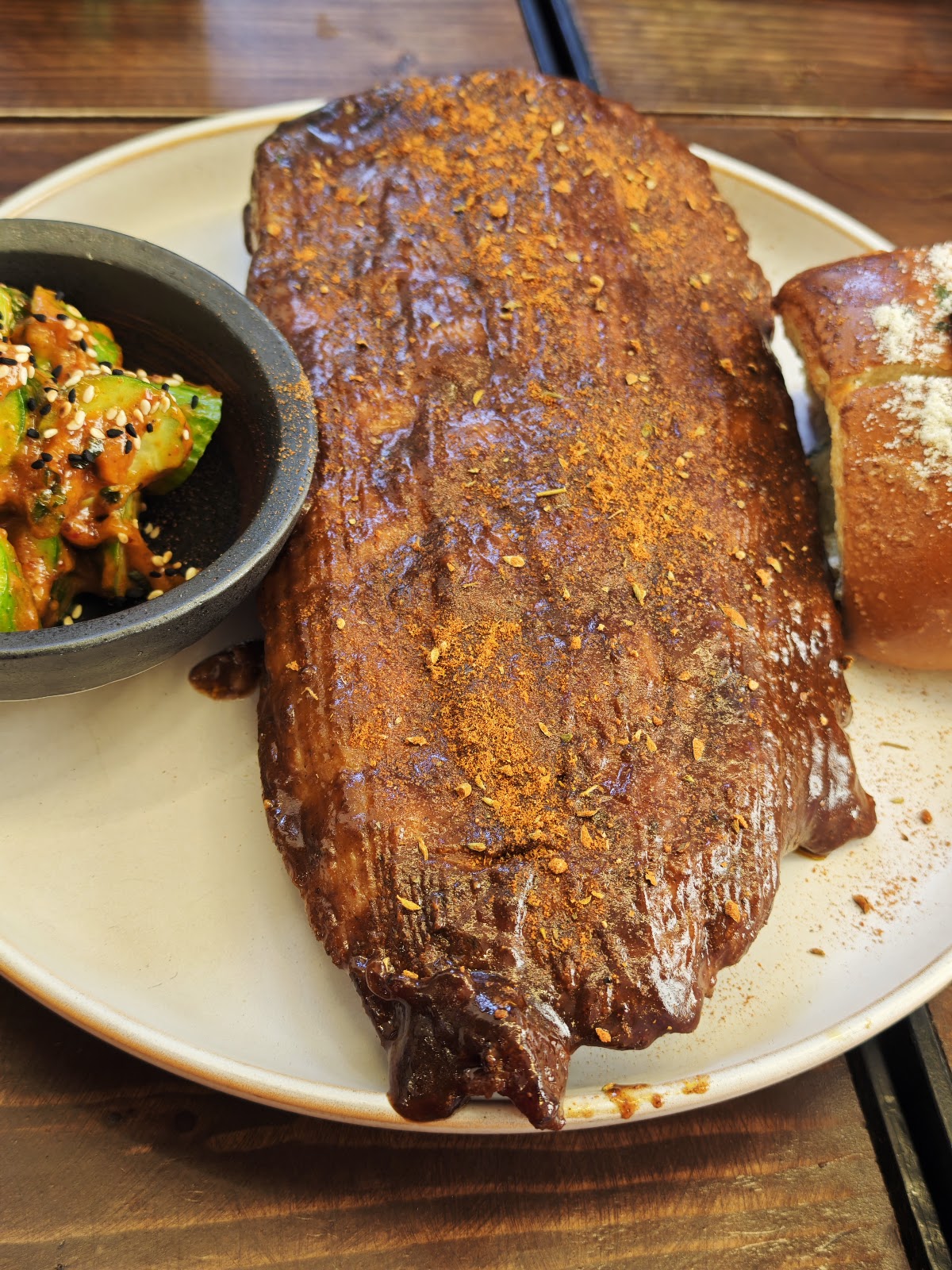 A full rack of ribs with spice dust on a white plate
