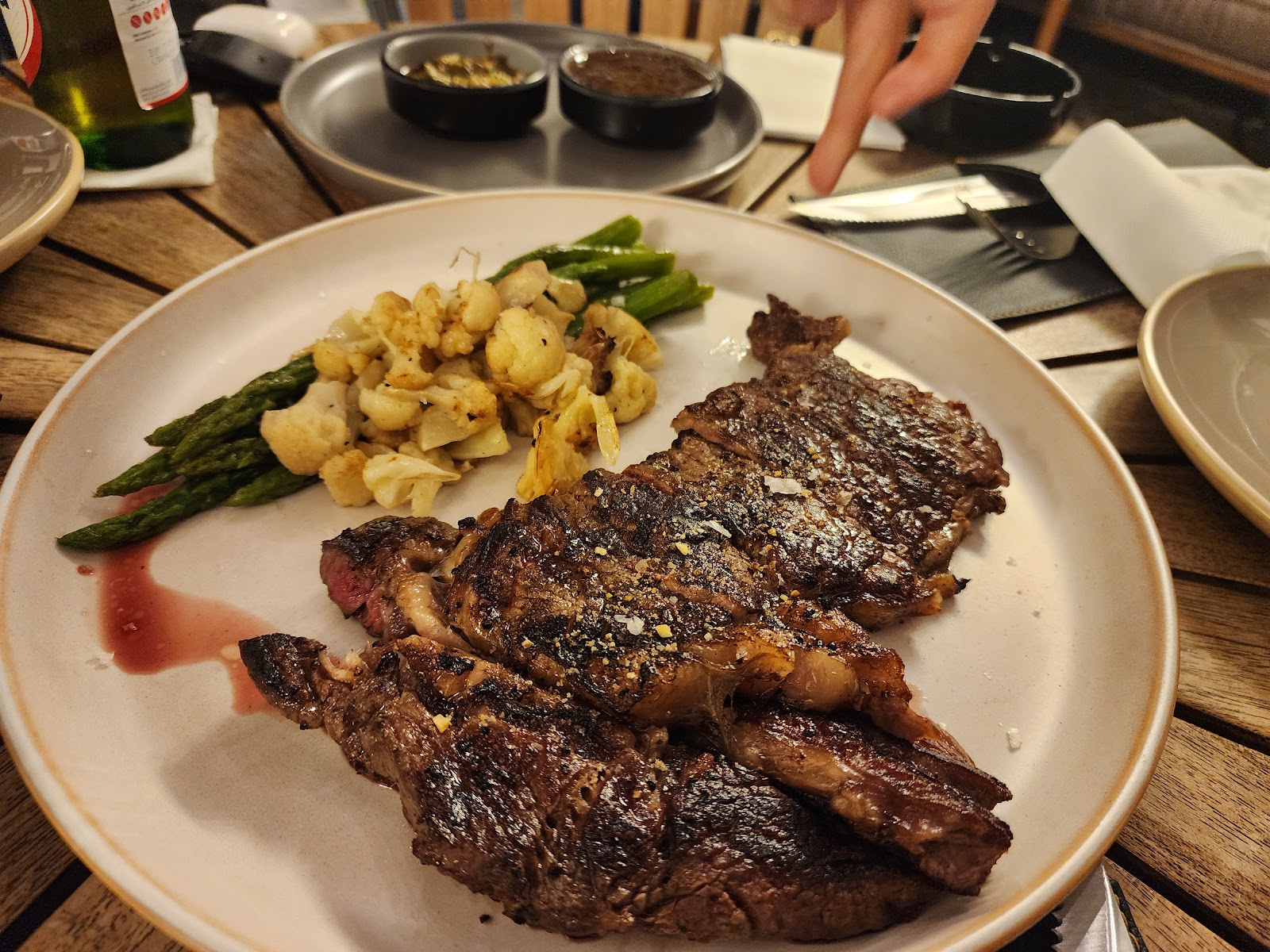A grilled steak plated with asparagus and roasted potatoes at Meats and Bread