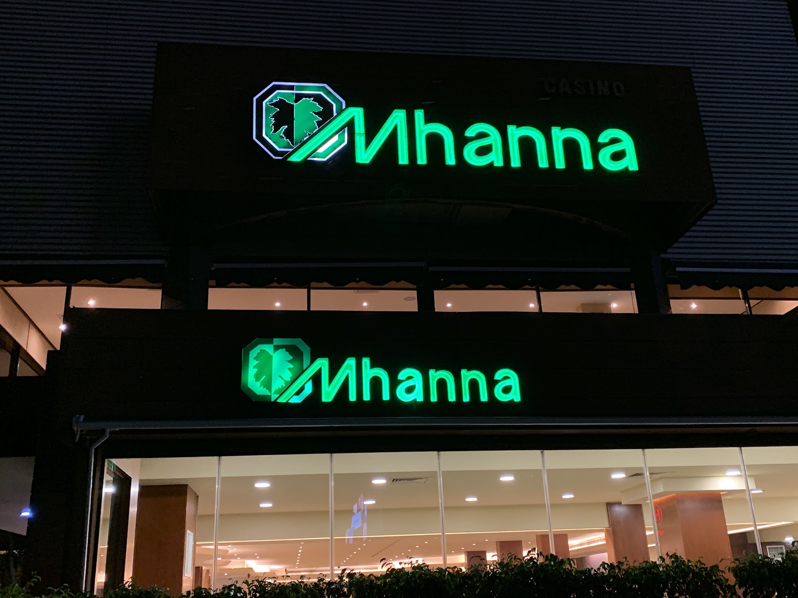 The green Mhanna neon signs glowing at night