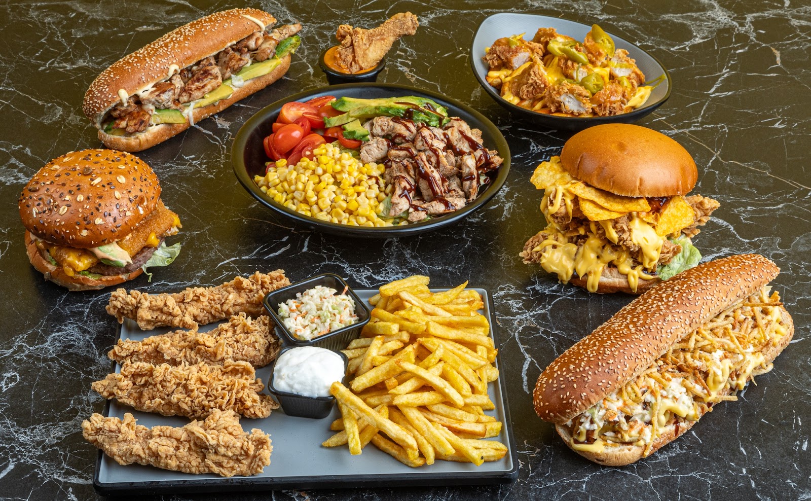 A Mr ComBoS spread: burgers, subs, tenders and fries laid out on the counter