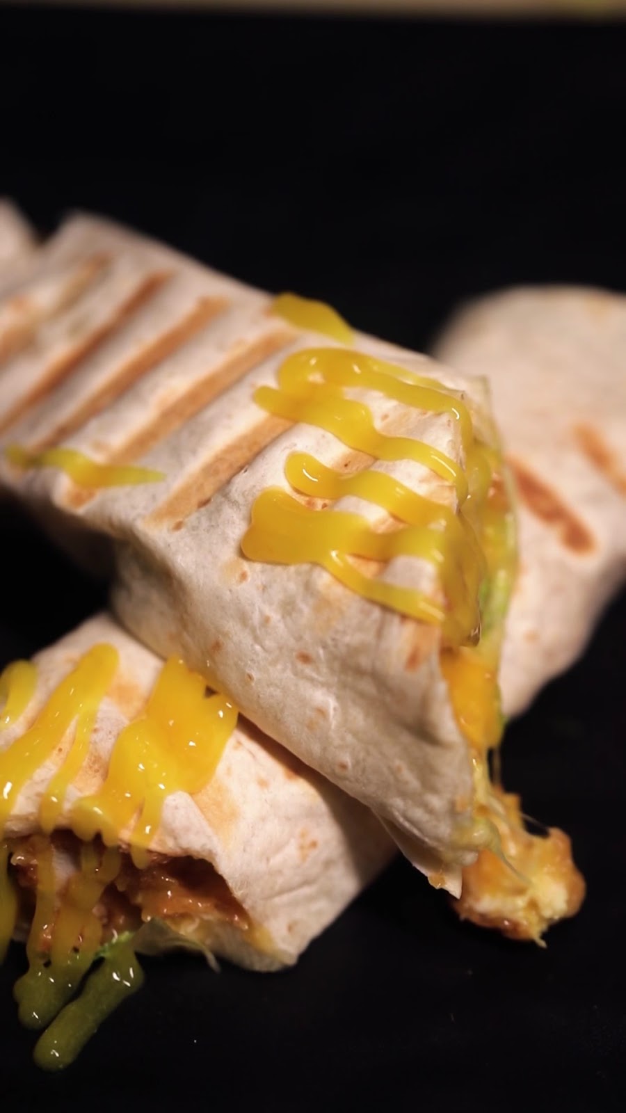 A pressed wrap cut open with cheese pulling