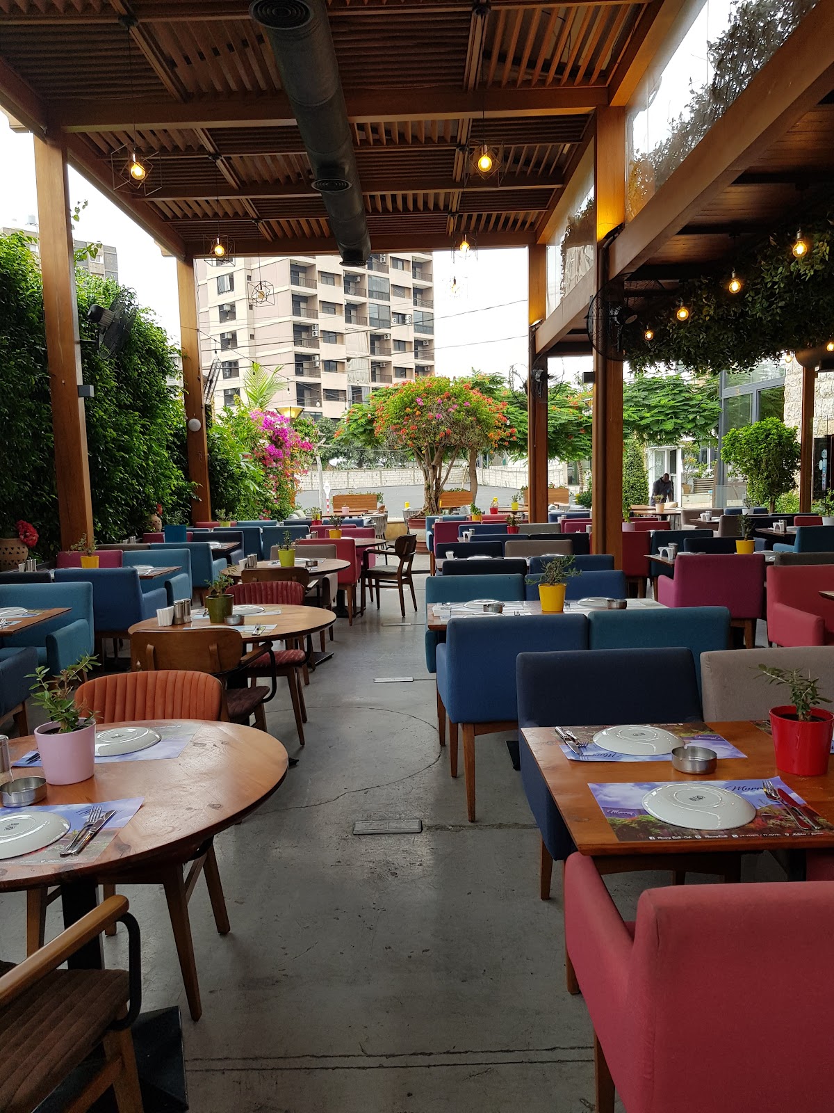 The garden terrace with colourful chairs under the pergola