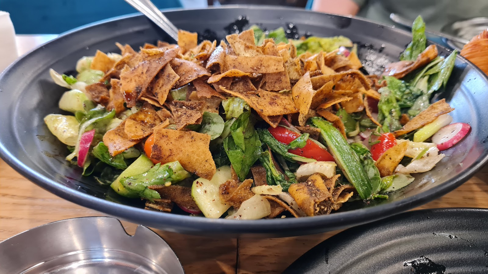 A big fattoush bowl with crisp bread on top