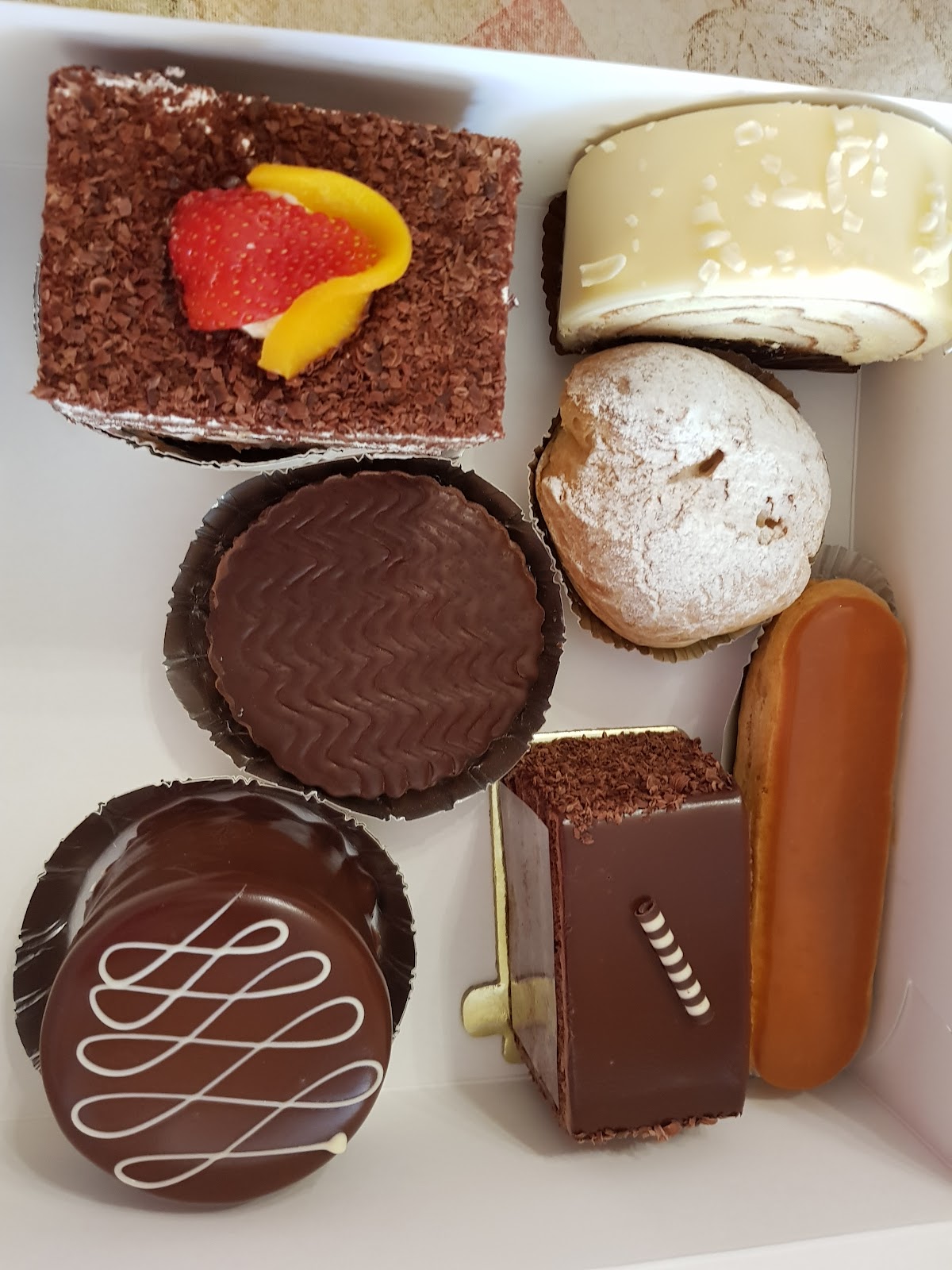 A boxed assortment of chocolate pastries and eclairs