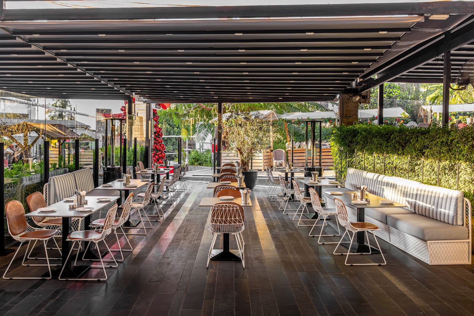 The covered terrace of The Backyard with its long benches and greenery