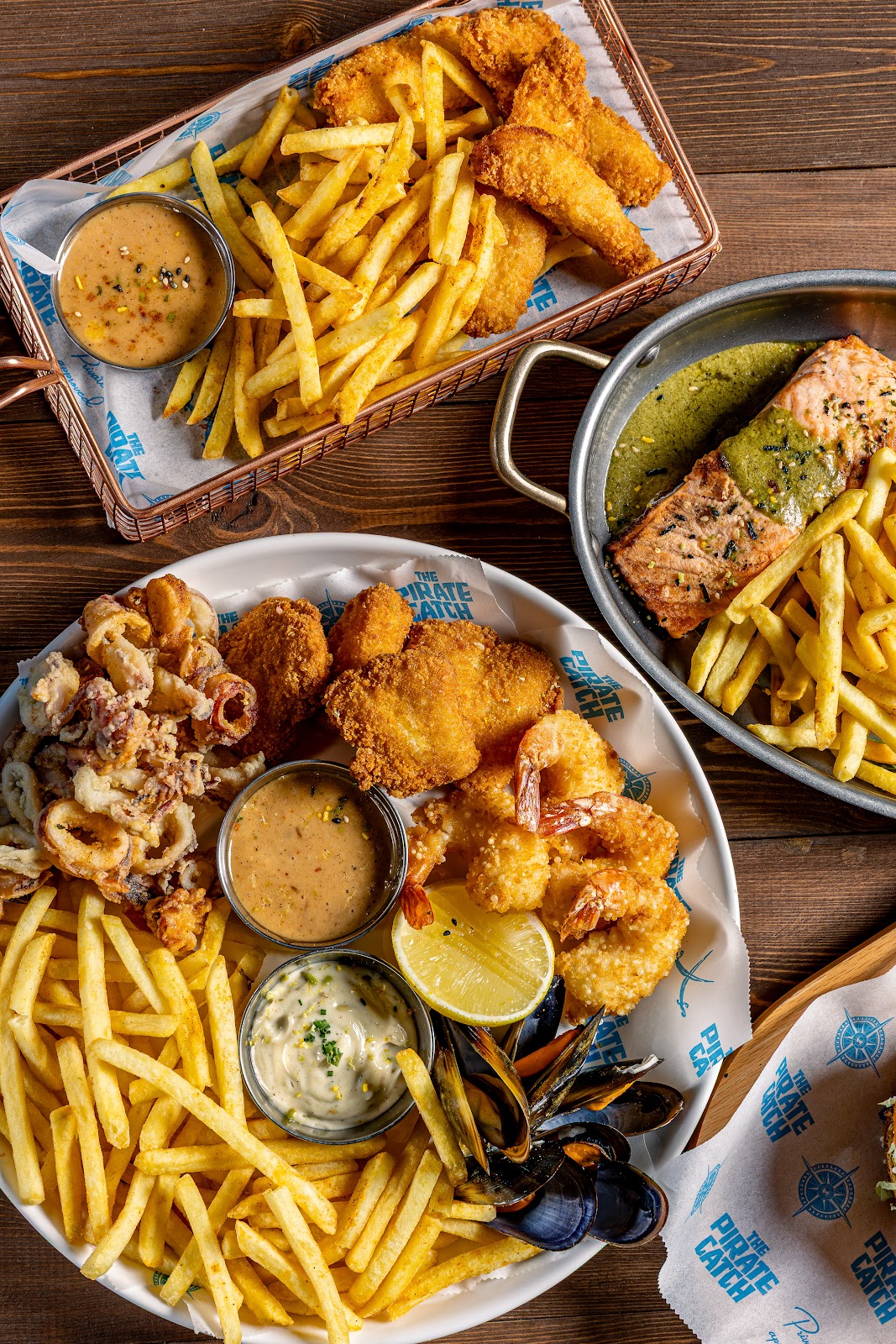 A Pirate Catch fried seafood platter with fries and dips, seen from above