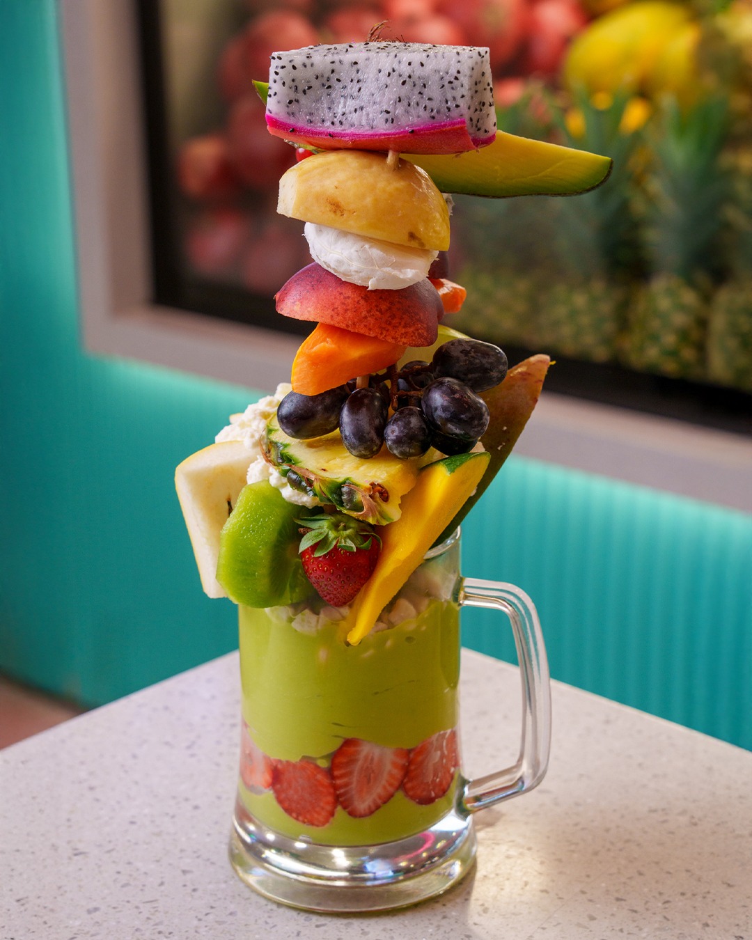 A tall Ramadan Juice fruit tower cocktail standing on the counter