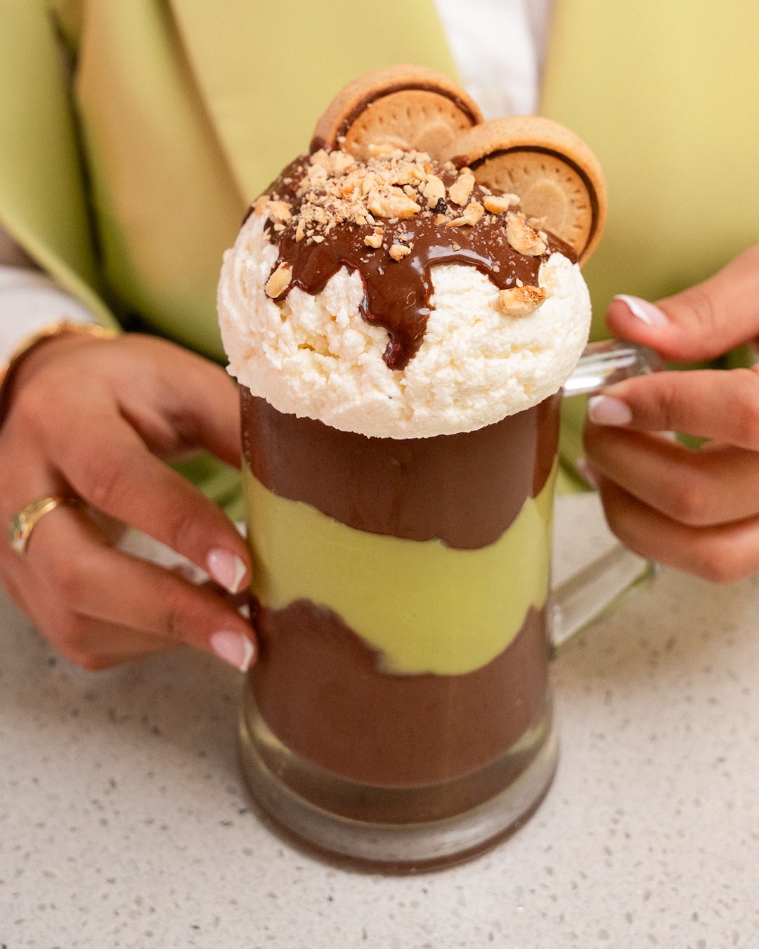 A layered Ramadan Juice cocktail topped with cream and crushed nuts