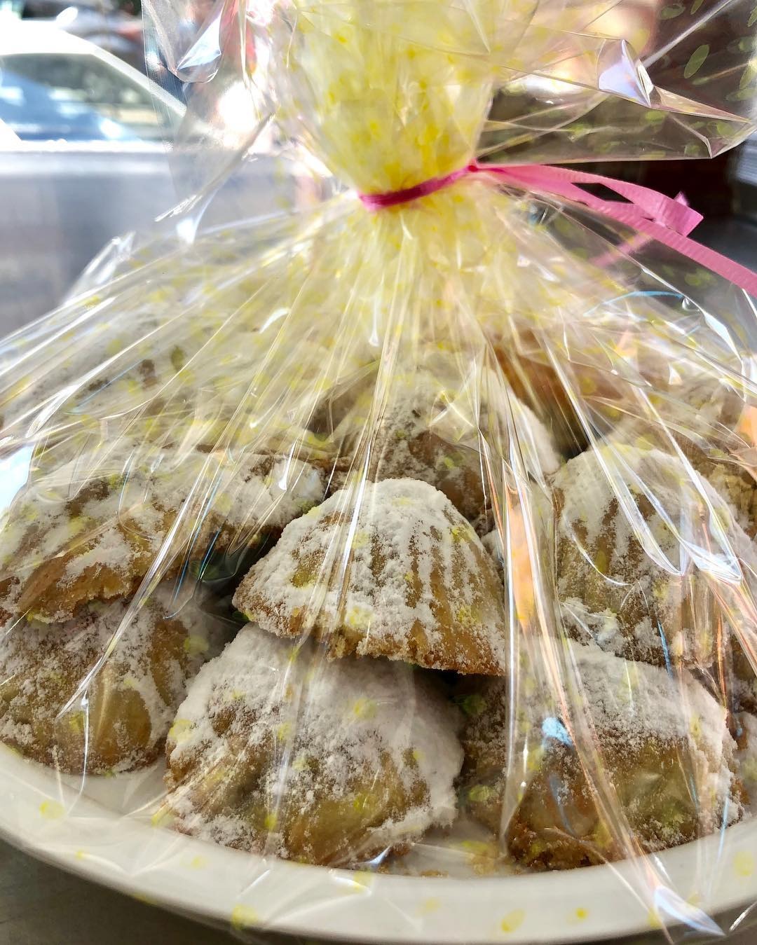 A tray of maamoul wrapped in cellophane and tied at the top