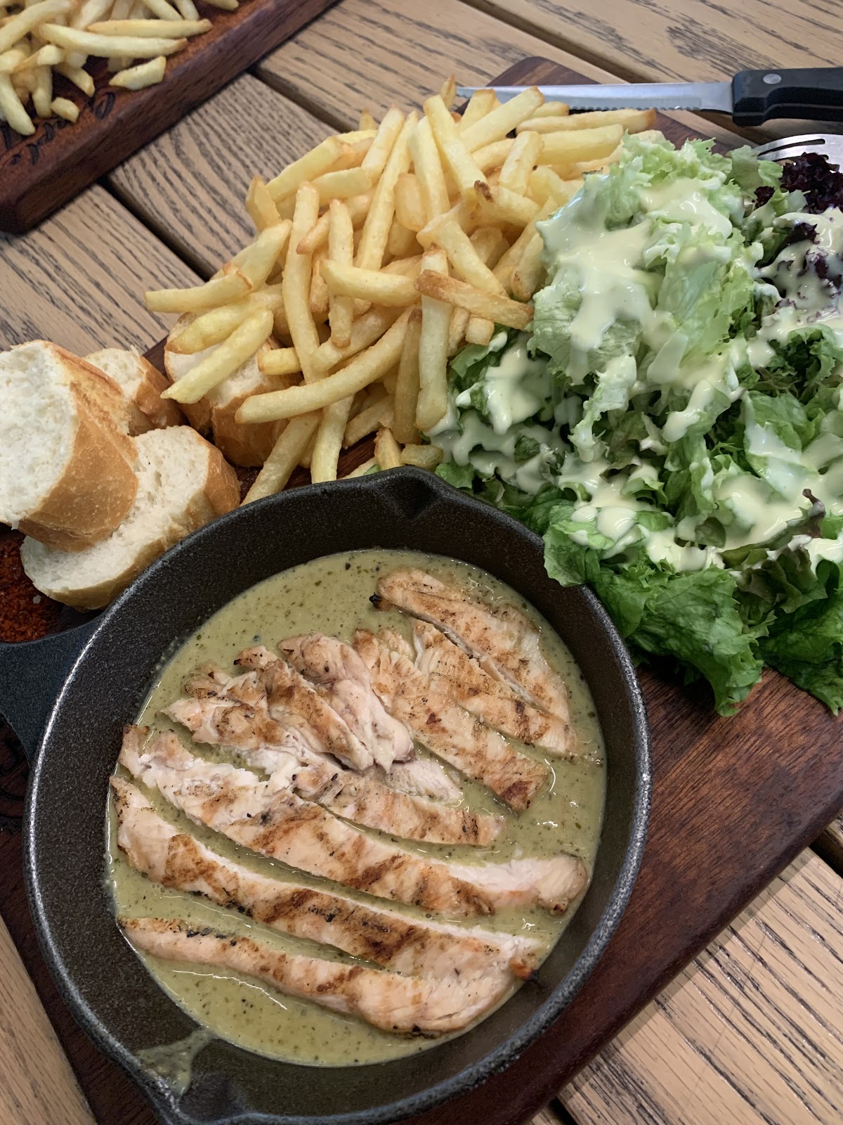 Chicken fillet steak in cream sauce with fries and salad