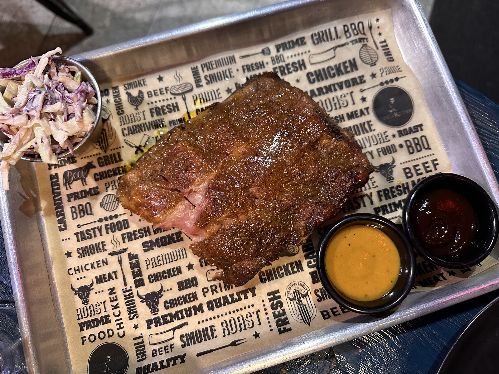 A smoked rack from The Smoking Barrels on the tray with the house sauces