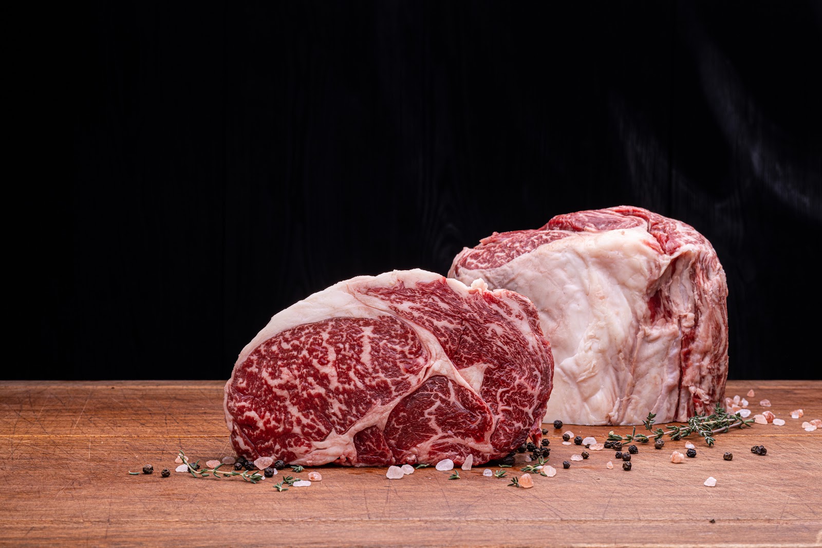 Marbled raw cuts of beef seasoned on the block