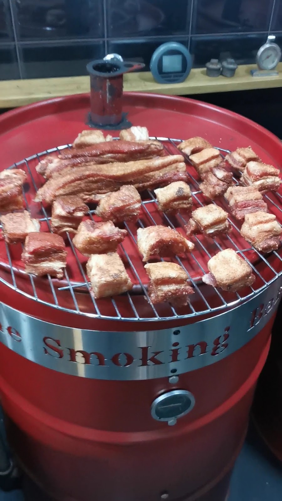 Pork belly cubes on the grate of the red barrel smoker